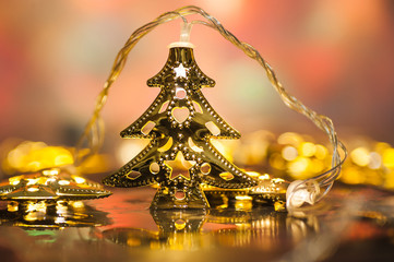 Christmas tree toy, on blurred, sparkling and magical background. Beautiful decorated shining gold garland.horizontal photo close up. bokeh. Happy New Year and Xmas theme