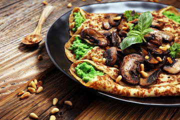Savory Homemade Mushroom and Spinach Crepes with Cheese and avocado.