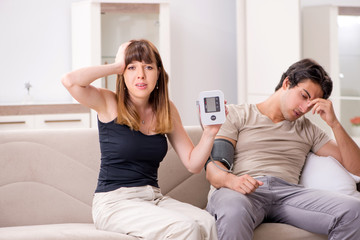 Wife checking husband's blood pressure 