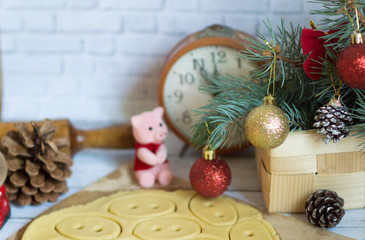  Preparing for Christmas and making cookies in the shape of a Piglet ckk treat and as a gift. Symbol of the decoration of the year Chinese calendar. With the branches of the Christmas tree and toys 
