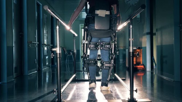 A person with special device walks in a clinic hallway. 4K.