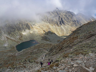 Panorama from Bystra lavka 2300m with the mountain lake Capie and Okruhle pleso with hikers climbing up, Mlynicka dolina and peak Strbsky stit 2381m , slovakian high Tatra mountains. fog and dramatic © Kristyna