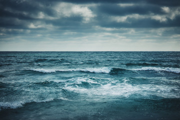 Water waves on cloudy sky background
