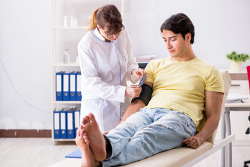 Young doctor checking patients blood pressure