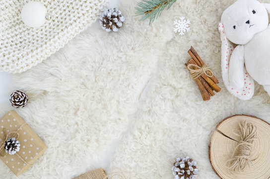 Flat lay fur background with pine cone fir branch,rope,rabbit toy, cinnamon.Top view copy space mockup. Cosy, soft ,minimal. Christmas,new year, birthday, xmas