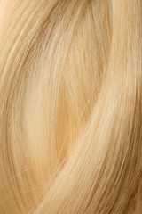 Texture of healthy blond hair as background, closeup