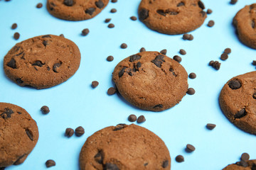 Delicious chocolate chip cookies on color background