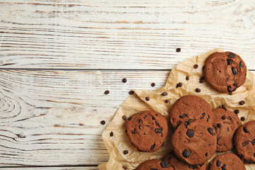 Delicious chocolate chip cookies on wooden table, flat lay. Space for text