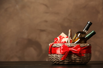 Gift basket with bottles of wine on dark background. Space for text