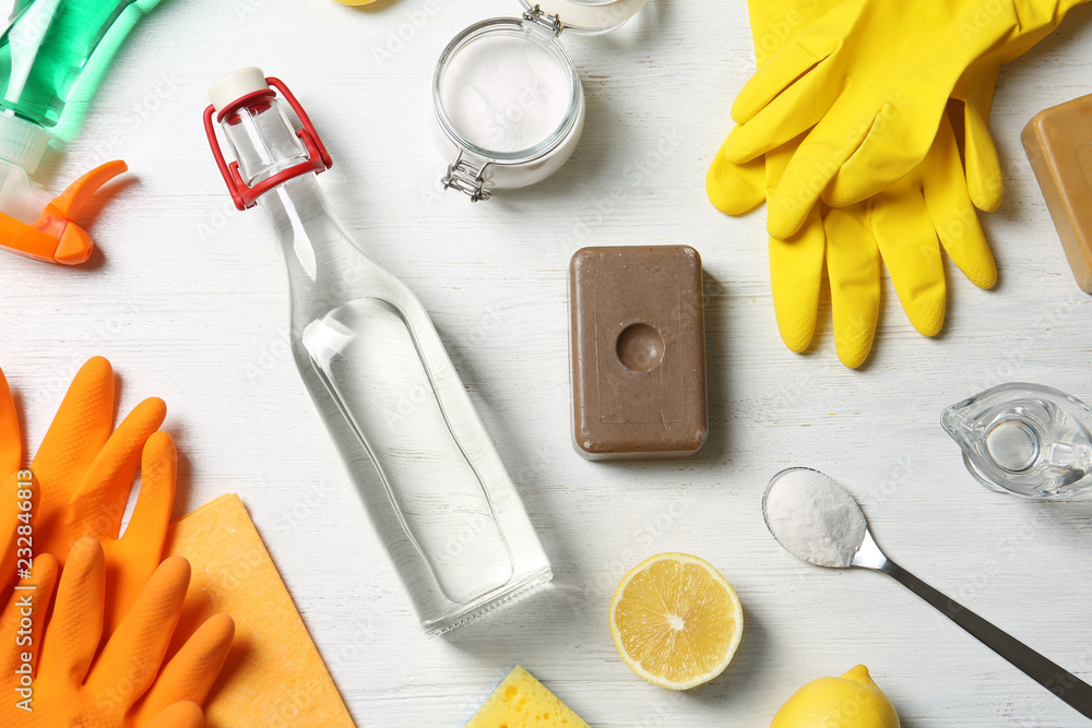 Wall mural flat lay composition with vinegar and cleaning supplies on white wooden background