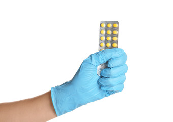 Doctor in medical glove holding pills on white background