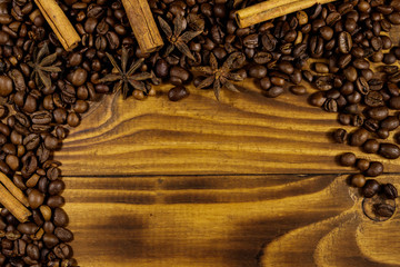 Coffee beans, cinnamon sticks and star anise on rustic wooden background. Top view, copy space