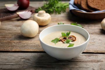Bowl of fresh homemade mushroom soup on wooden table