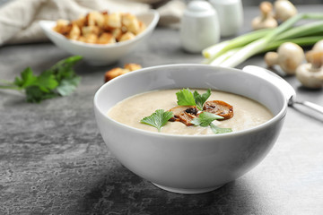 Bowl of fresh homemade mushroom soup on gray table