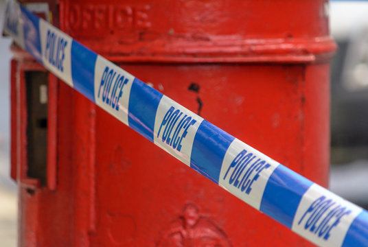 British Police Tape In Front Of Red Post Box