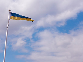 Die schwedische Fahne an einem Fahnenmast am blauen bewölkten Himmel.
