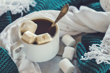 Cup of coffee and marshmallow with white and green scarfs
