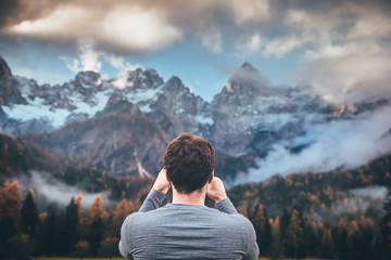 Man looking at mountains in autumn time. Julian Alps in background. Slovenia, Kranjska Gora