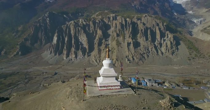 Aerial drone scenic view revolving around Buddhist stupa above dry high altitude Himalayan valley landscape vista above Manang village in Nepal. 4k 1.9:1 23.976fps