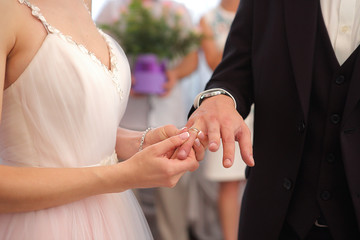 Marriage ceremony. Bride puts ring to groom