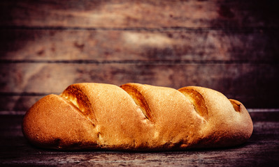 Wheat bread on a wooden table and background.