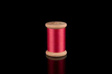 Pink Thread, Cerise Pink Wooden Thread Bobbin isolated on black Background, reflections, Copy...