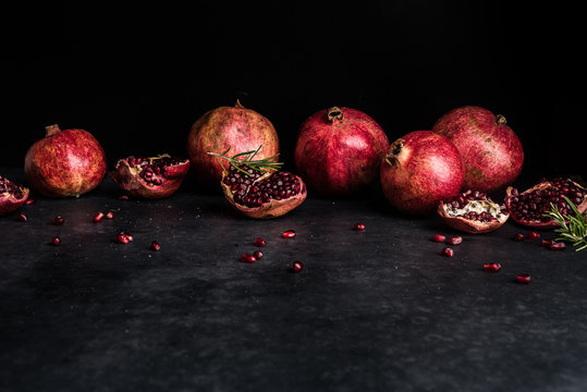 Whole pomegranates and sections with rosemary