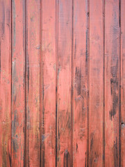 Close-up of old red wooden planks wall texture. Vintage style, rustic wood texture with natural patterns surface as background. Vertical layout. High-quality macro photography.