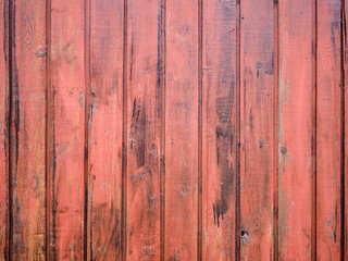 Close-up of old red wooden planks wall texture. Vintage style, rustic wood texture with natural patterns surface as background. Vertical layout. High-quality macro photography.