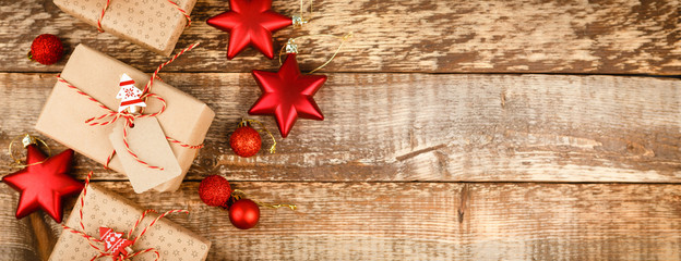 Christmas background with decorations and gift boxes on wooden board