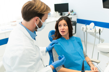 Dentist and beautiful woman patient in the dentist office.