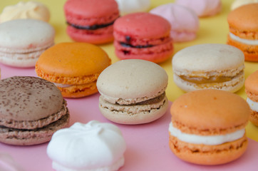 Fototapeta na wymiar Assortment of macarons and meringues on pink background