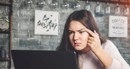 girl with poor eyes working with laptop, eye disease,  girl looks into the laptop