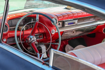 Close up interior of a classic retro / vintage american car of 1950s,  steering wheel clock, dashboard, speedometer. The car is Taxi in Havana, Cuba. Outdoor.