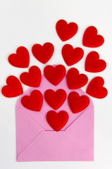 Valentine Day greeting card with heart. Red hearts pours fly out of the opened envelope on white. Love Letter. Flay lay
