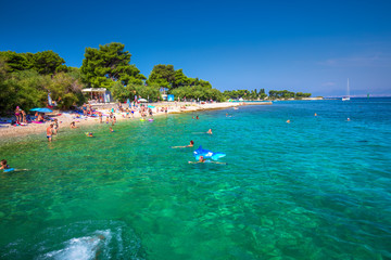 Fototapeta na wymiar Pebble beach on Brac island with turquoise clear ocean water, Supetar, Brac, Croatia