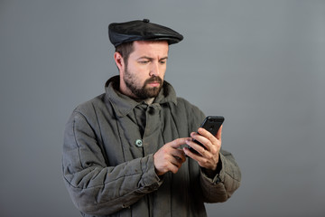Caucasian man 35 years old with concentrated look at smartphone, studio shot. Idea - village...