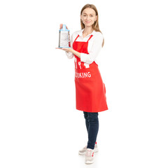 A woman in a red apron in the hands kitchen grater on a white background. Isolation