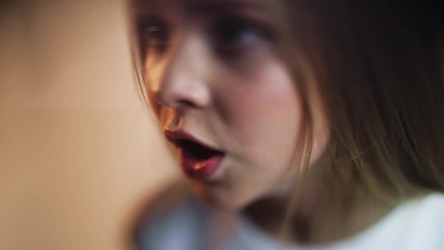 Close up face young blonde girl makes an angry face talk speak white background sad child cute fashion little moody playful studio expression kids portrait slow motion