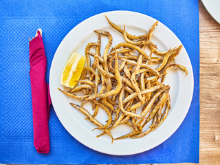 Pescaito frito, fried fish Andalusian style on a tavern table.