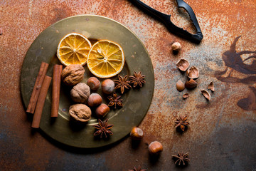 Holiday spices and nuts on a rustic background.