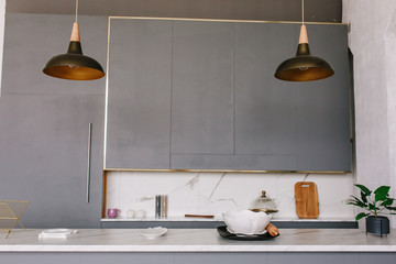 Black loft kitchen lamps in a modern style with gray cabinets, white lockers and shelves with...