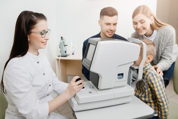 Young attractive girl doctor ophthalmologist sitting on chair for special ophthalmological equipment