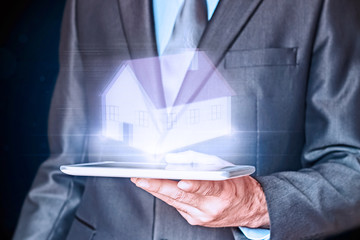 Businessman holding a virtual house. Virtual Holographic House. Business, mortgages and families...