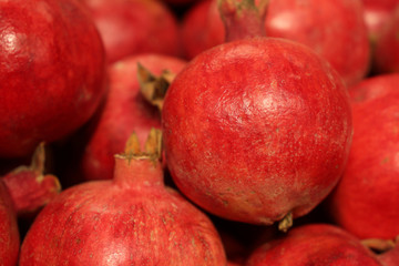 Fototapeta na wymiar Ripe pomegranates close-up, selective focus. Red pomegranate fruits on the market, natural background