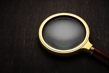 Golden magnifier on a dark background.