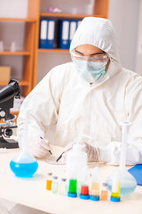 Young biochemist wearing protective suit working in the lab