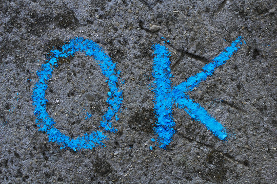 Colorful chalk drawing on asphalt: word OK