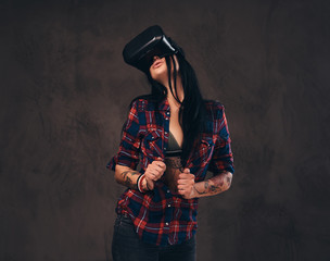 Tattooed girl wearing a red unbuttoned checked shirt wearing a VR headset.