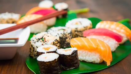 Maki and nigiri sushi set on green leaf  background. Close up